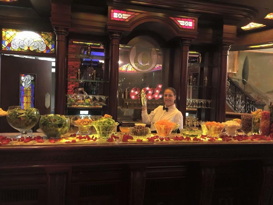 Salad bar styled along a wood-paneled bar with staff in uniform